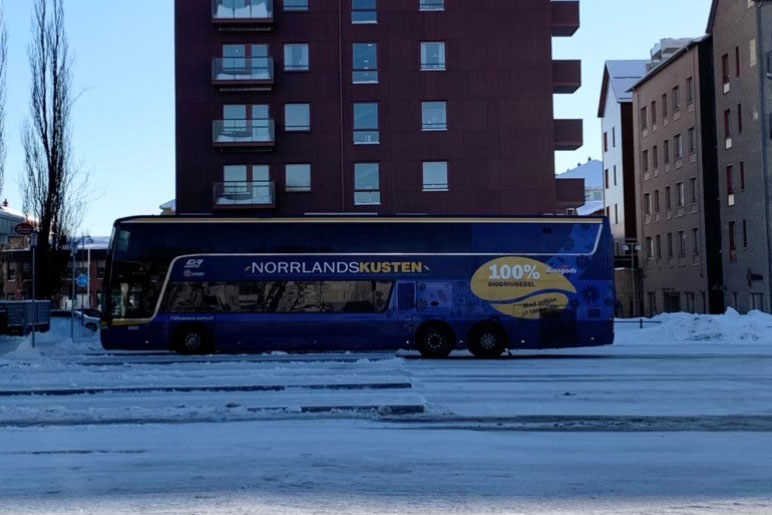 En långfärdsbuss som kör på en väg.